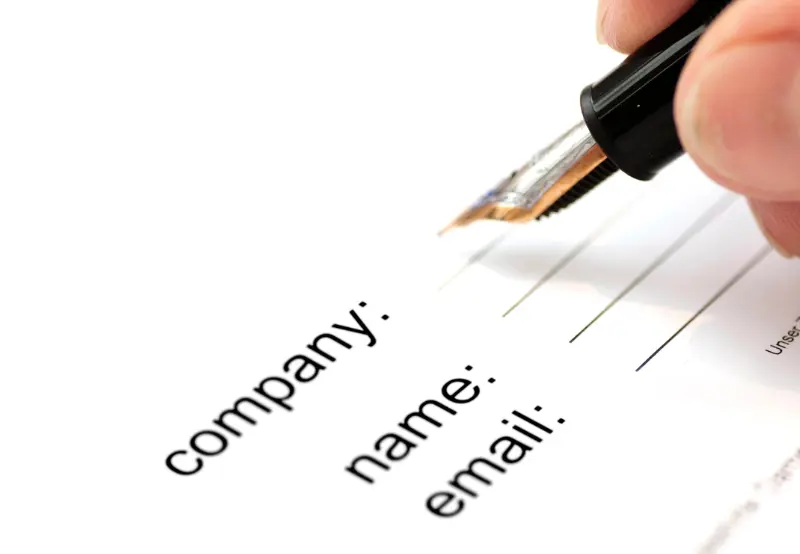 writing down dental practice's company name on form