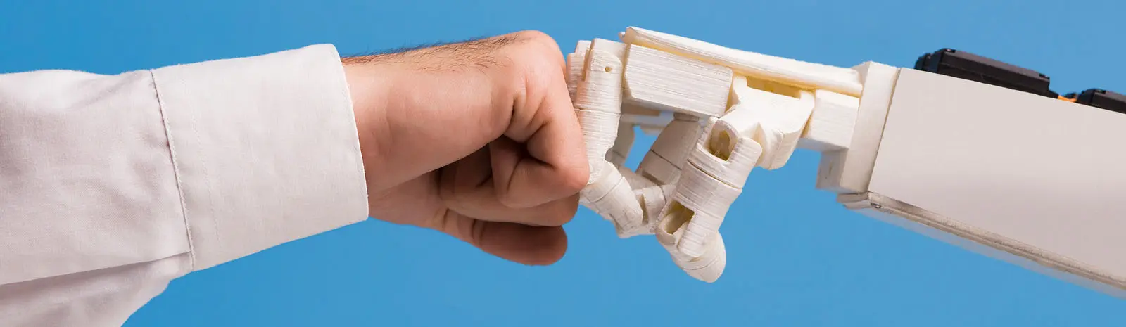 Man and robot punching fists, successful coworking of human and ai
